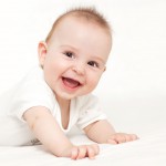 Portrait of a beautiful 6 months baby smiling, on white background