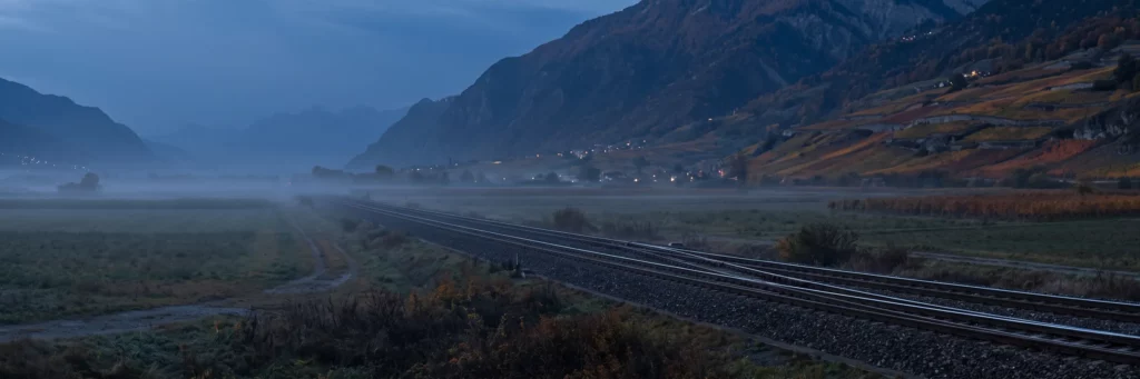 Swissdec 6 : une voie ferrée qui se sépare en deux voies parallèles en Valais, à l'heure bleue